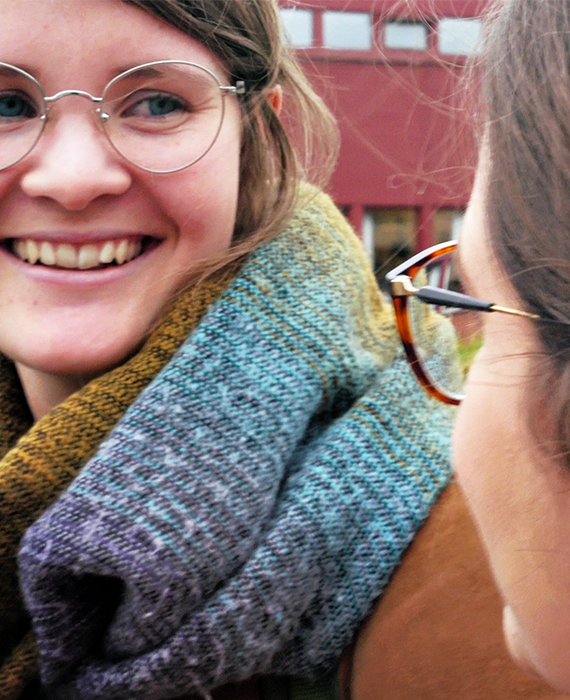 Bildtext: Närbildsfoto på en person som pratar med en annan. 