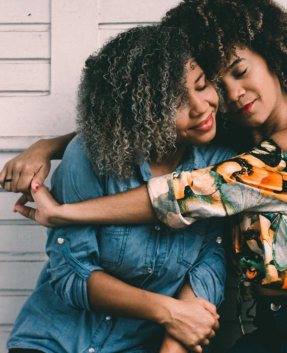 Bildtext: Foto på två tjejer som kramar varandra